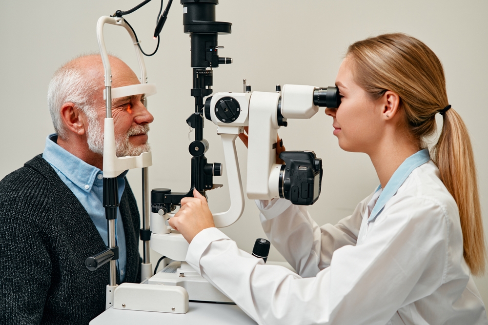 An eye doctor performs an eye examination on an older man using specialized equipment - Carrboro Eye Doctor An eye doctor performs an eye examination on an older man using specialized equipment - Carrboro Eye Doctor